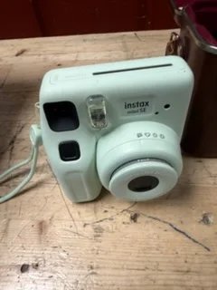 A compact instant camera photographed before it was hidden